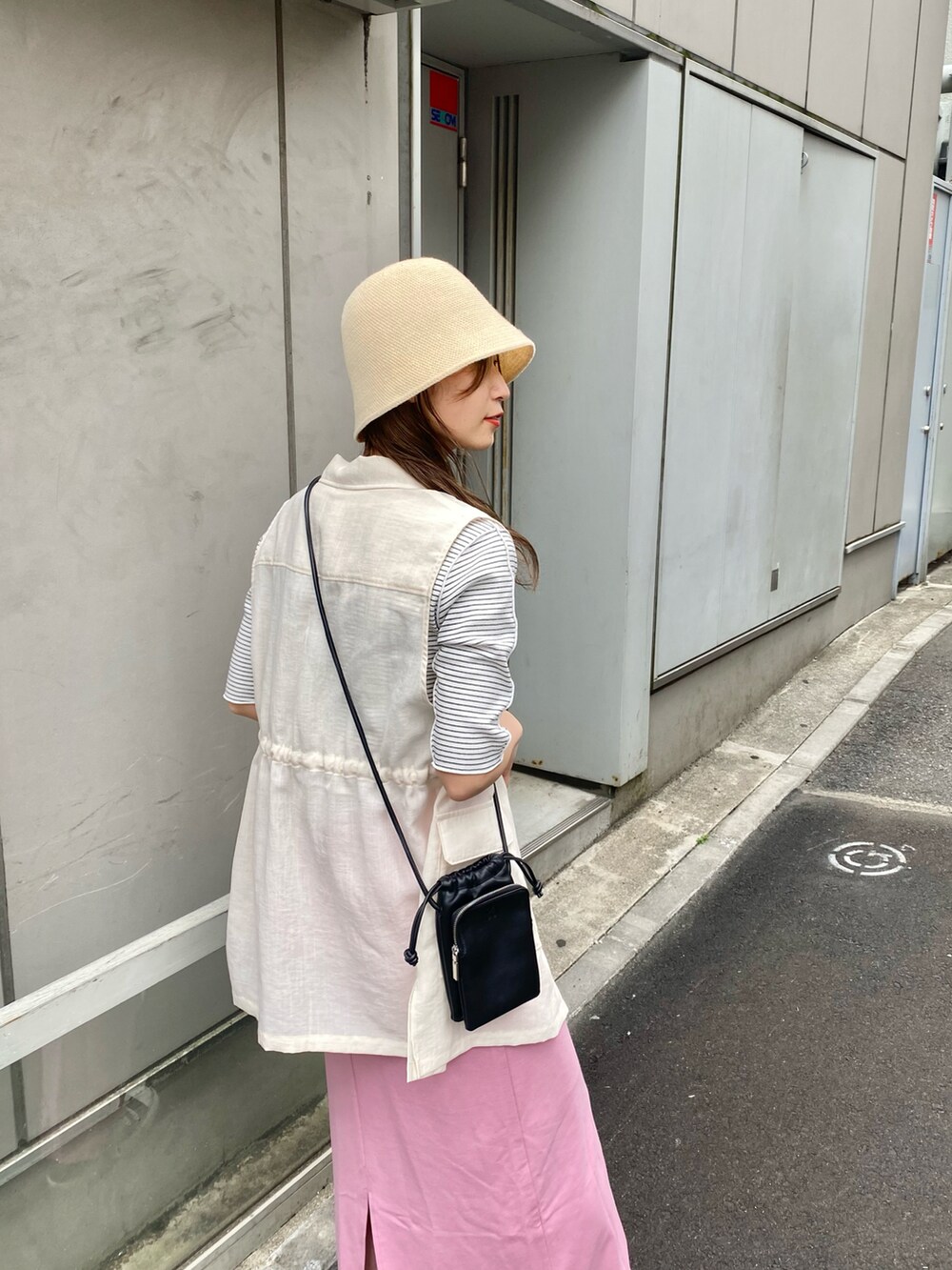 ピンク系のスカート、ホワイト系のベスト、ホワイト系のTシャツ/カットソーを着用したレディースの春コーディネートの3枚目の写真