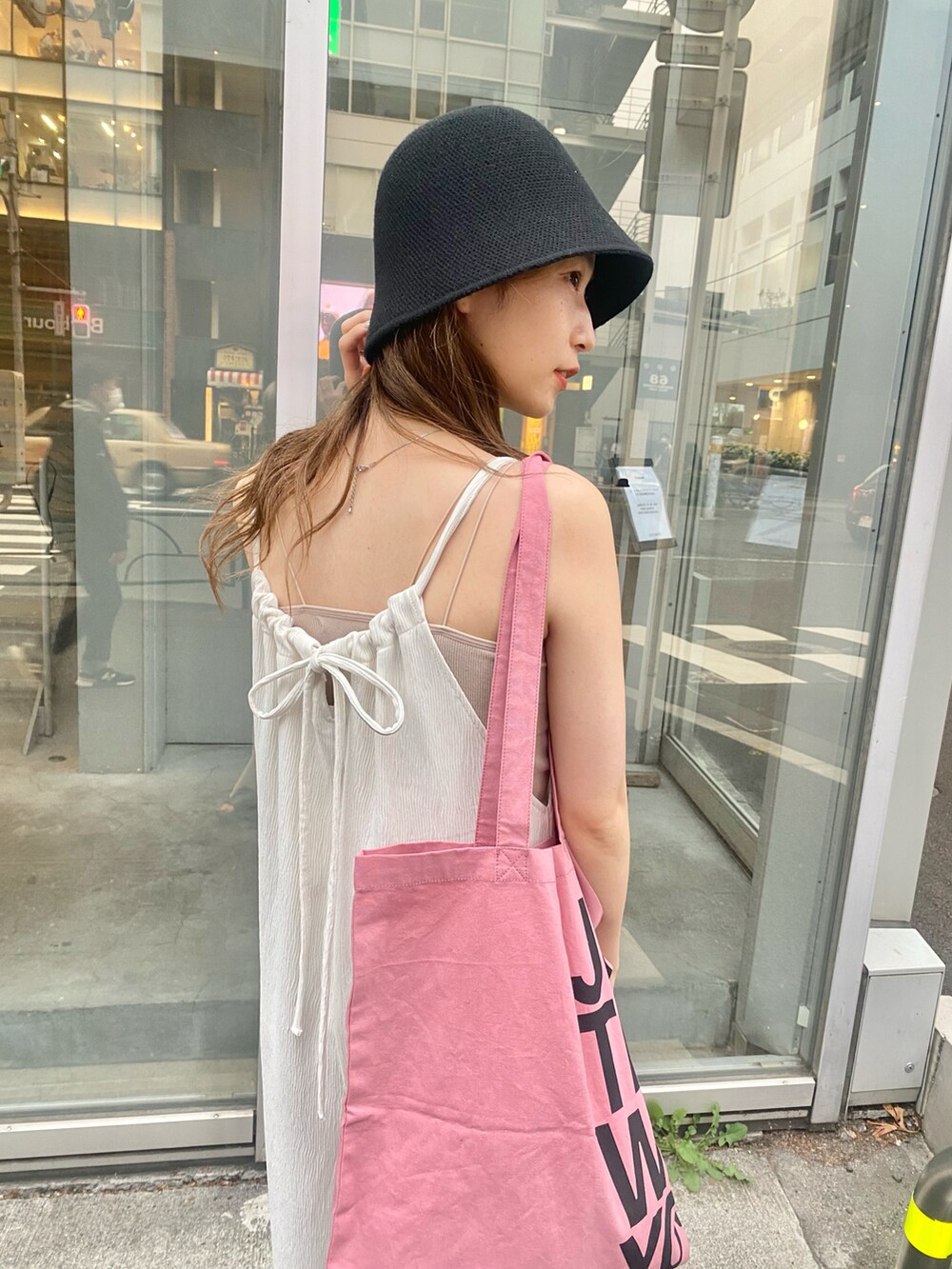 ホワイト系のキャミソール、ホワイト系のサロペット/オーバーオール、ピンク系のトートバッグを着用したレディースの春コーディネートの4枚目の写真