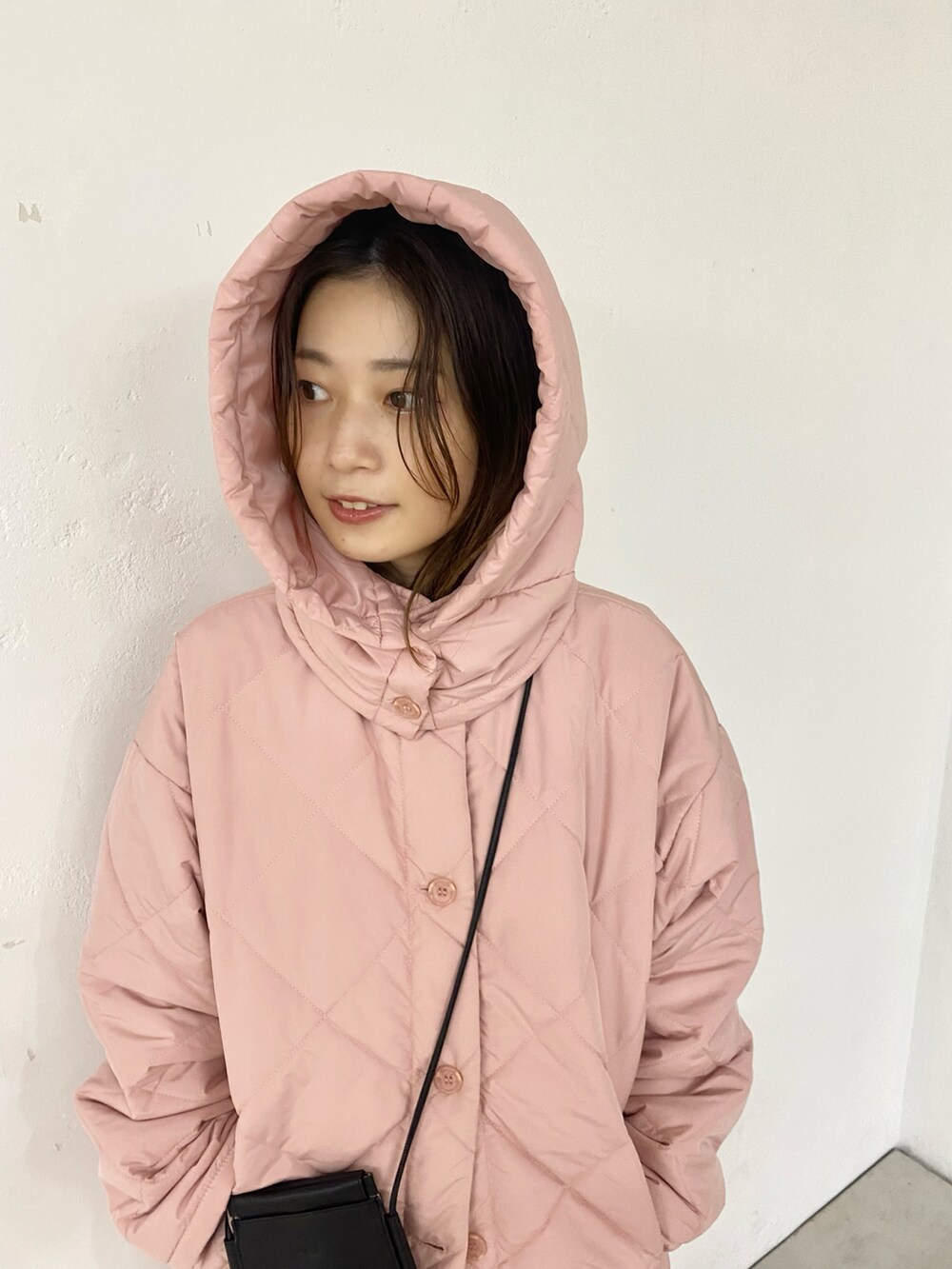 ブラック系のブーツ、ピンク系のダウンジャケット/コートを着用したレディースの秋コーディネートの3枚目の写真