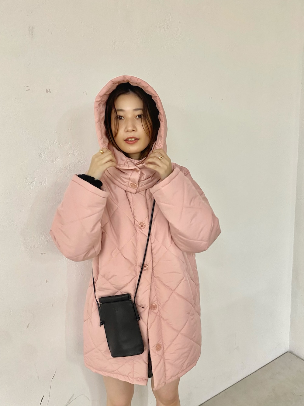 ブラック系のブーツ、ピンク系のダウンジャケット/コートを着用したレディースの秋コーディネートの4枚目の写真