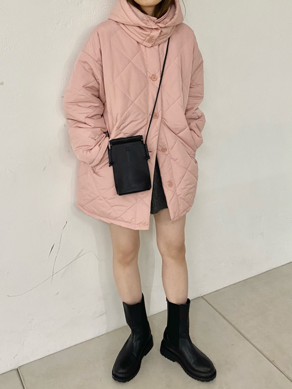 ブラック系のブーツ、ピンク系のダウンジャケット/コートを着用したレディースの秋コーディネートの5枚目の写真
