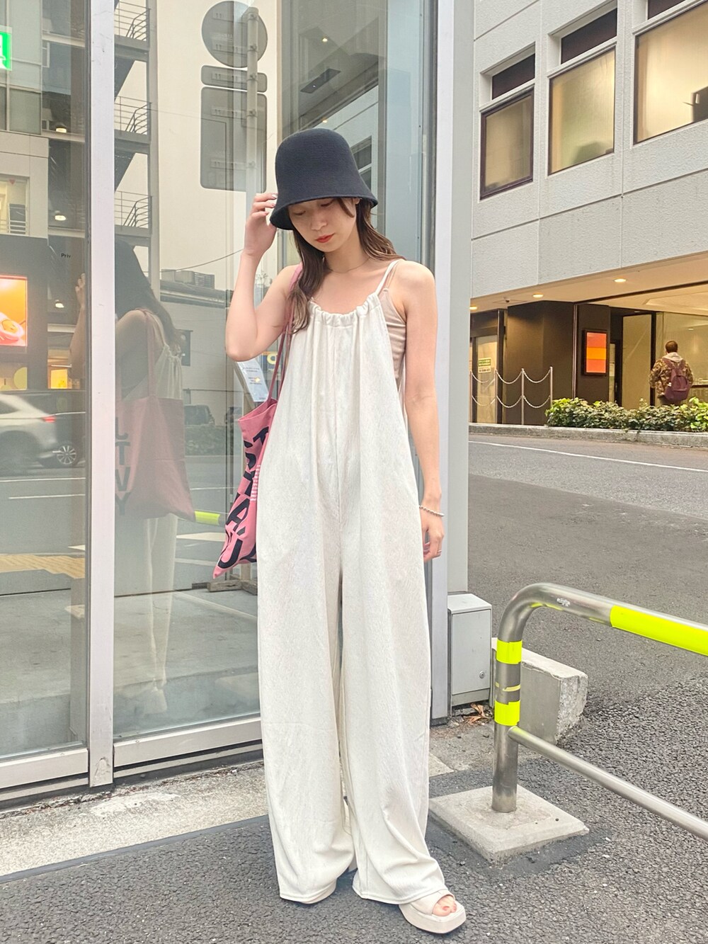 ホワイト系のキャミソール、ホワイト系のサロペット/オーバーオール、ピンク系のトートバッグを着用したレディースの春コーディネートの3枚目の写真