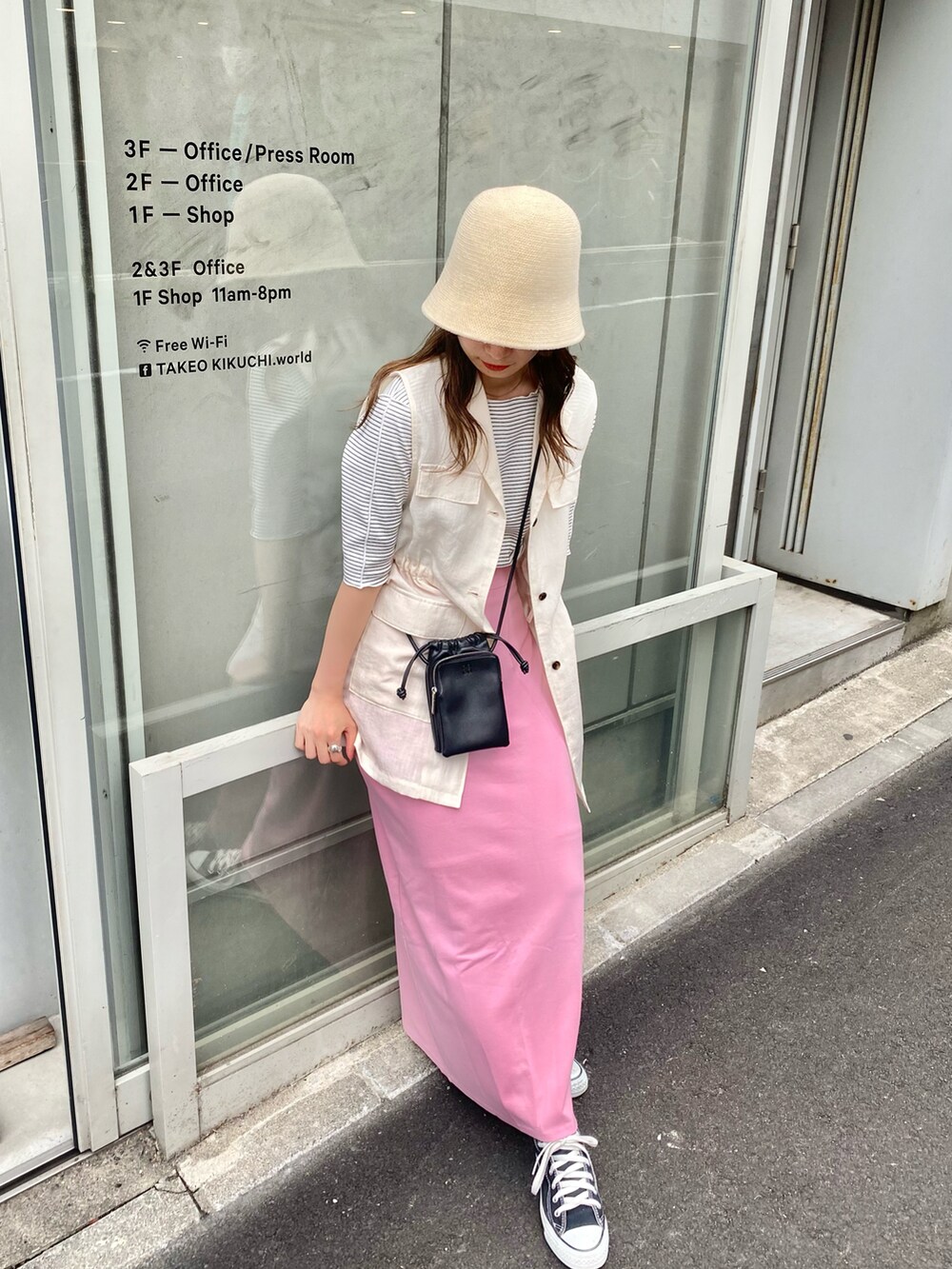 ピンク系のスカート、ホワイト系のベスト、ホワイト系のTシャツ/カットソーを着用したレディースの春コーディネートの2枚目の写真