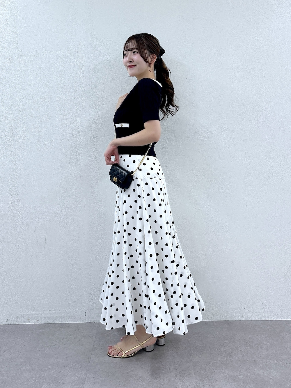 ブルー系のニット/セーター、ホワイト系のスカートを着用したレディースの春コーディネートの2枚目の写真