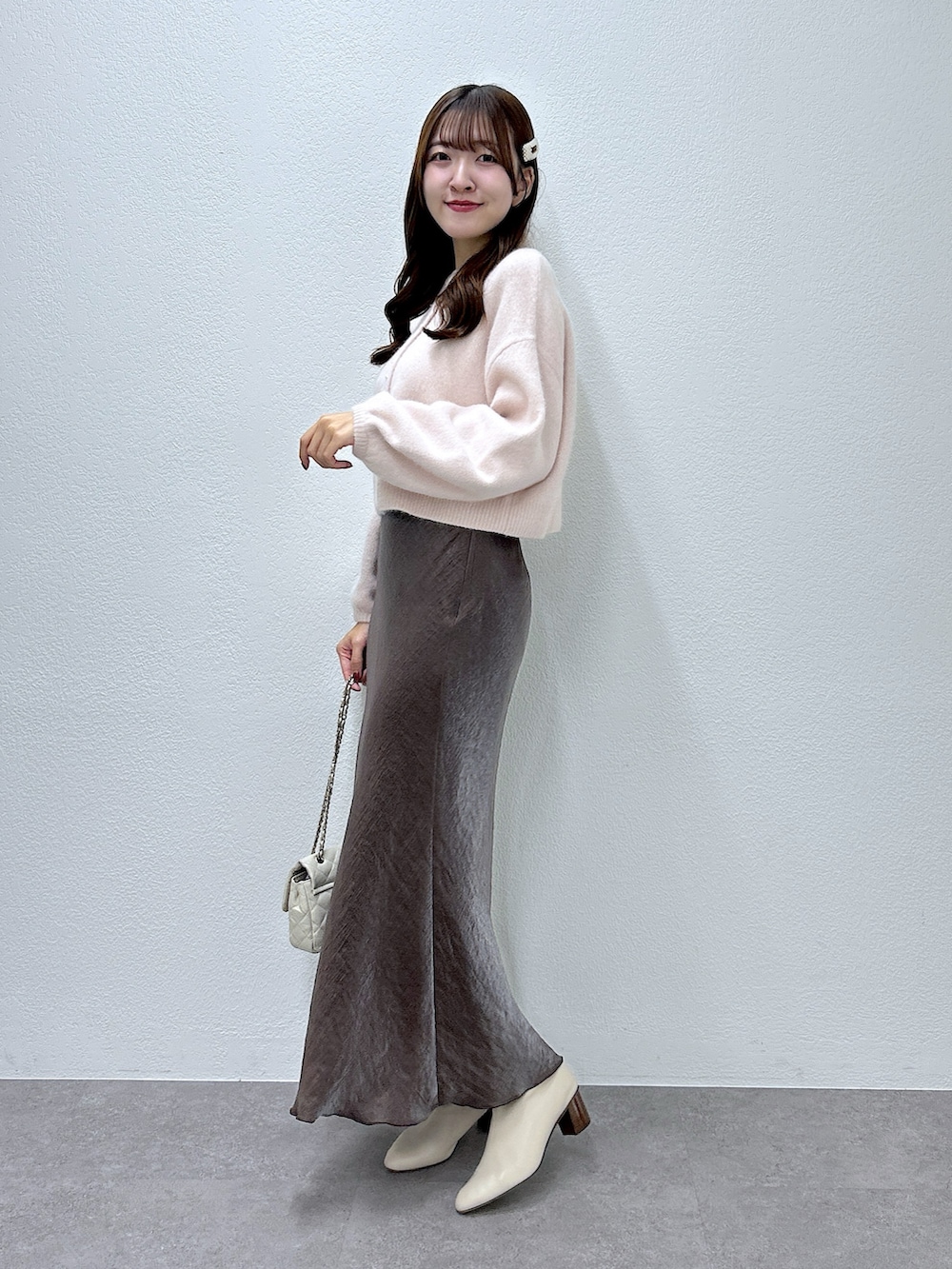 ピンク系のカーディガン/ボレロ、ブラウン系のスカートを着用したレディースの秋コーディネートの2枚目の写真