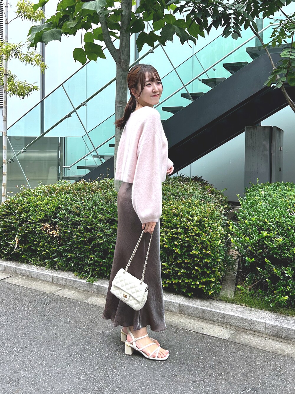 ピンク系のカーディガン/ボレロ、ブラウン系のスカート、ホワイト系のショルダーバッグを着用したレディースの秋コーディネートの3枚目の写真