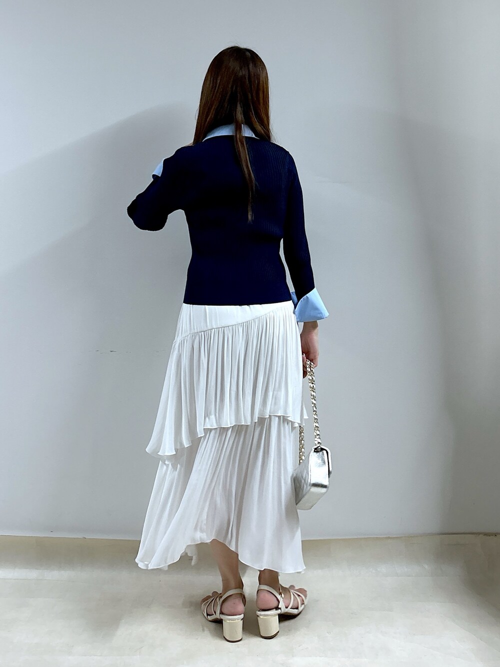 ブルー系のニット/セーター、ホワイト系のスカートを着用したレディースの秋コーディネートの4枚目の写真