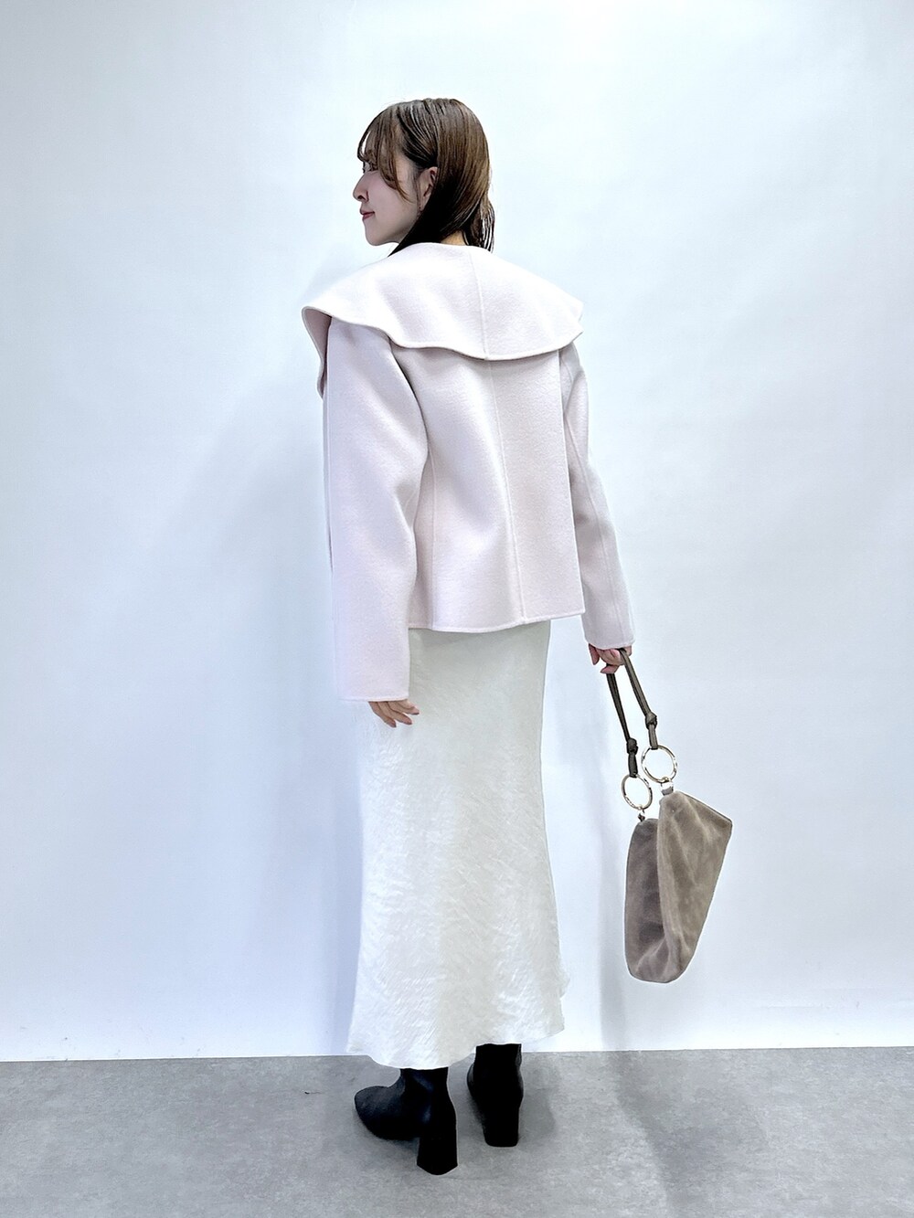 ピンク系のその他アウター、ホワイト系のニット/セーター、グレー系のスカートを着用したレディースの秋コーディネートの3枚目の写真