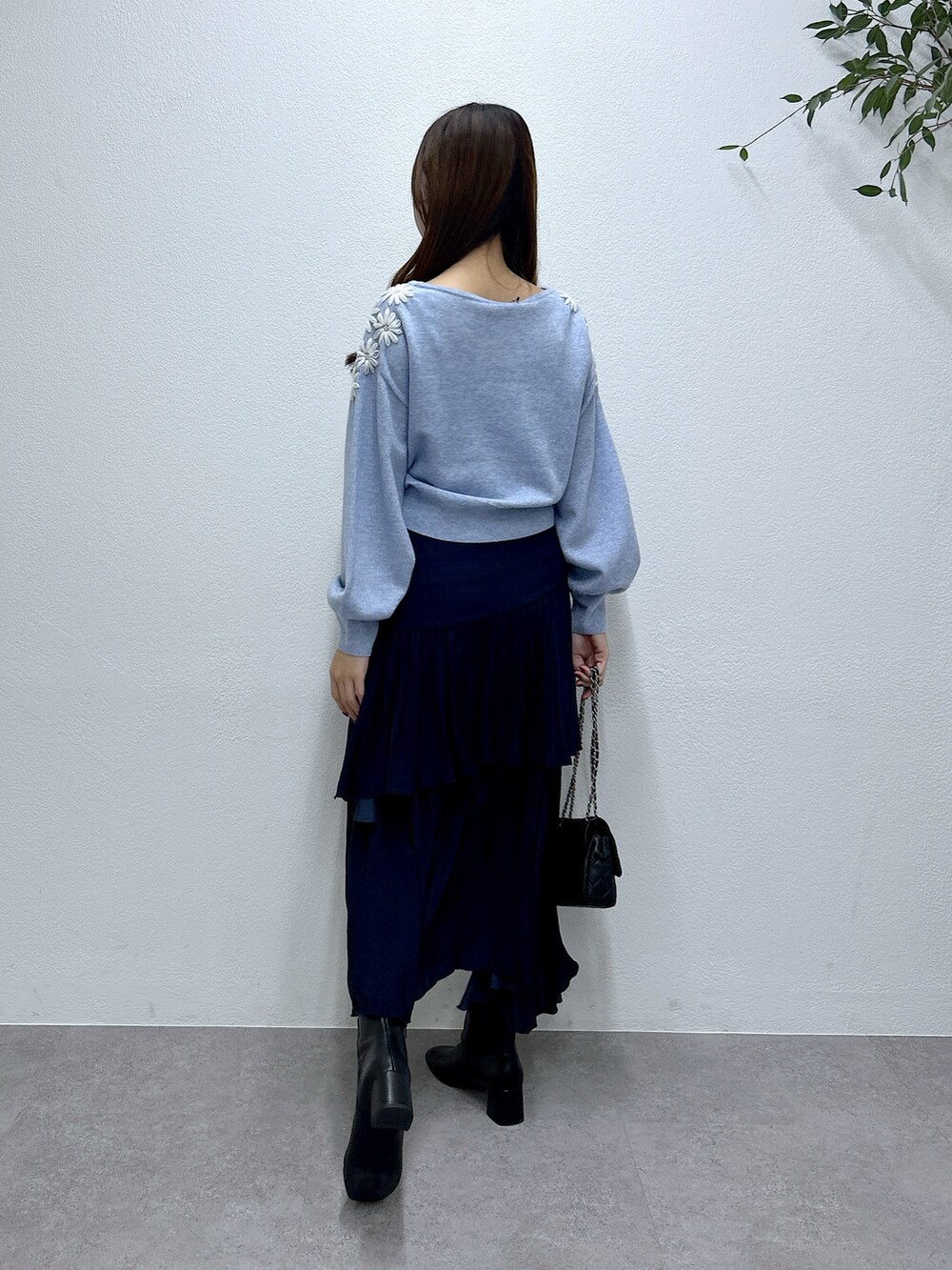 ブルー系のニット/セーター、ブルー系のスカートを着用したレディースの秋コーディネートの3枚目の写真
