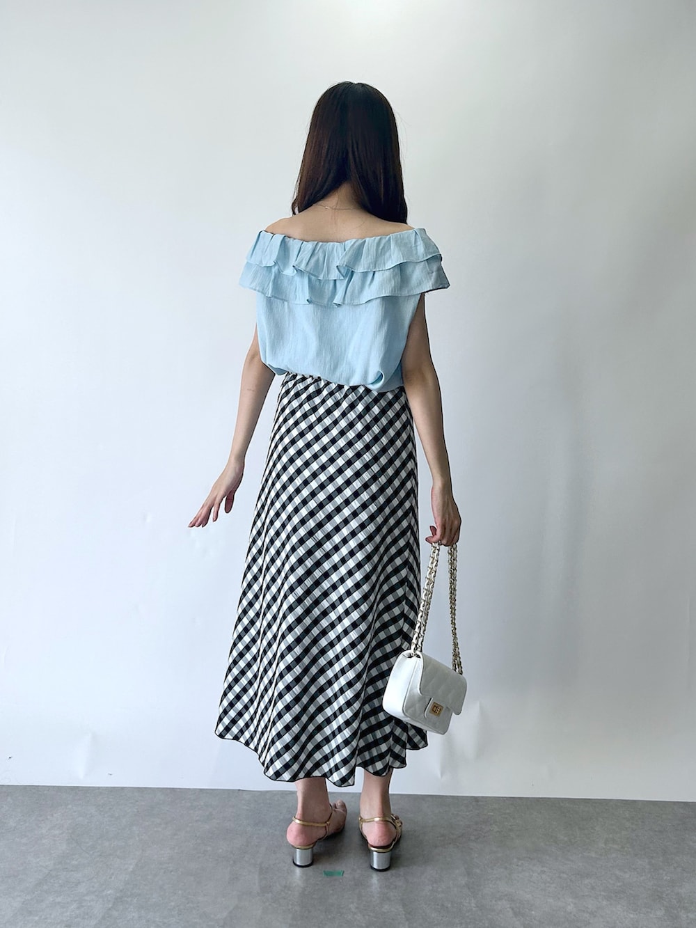 ブルー系のシャツ/ブラウス、ブラック系のスカートを着用したレディースの夏コーディネートの3枚目の写真