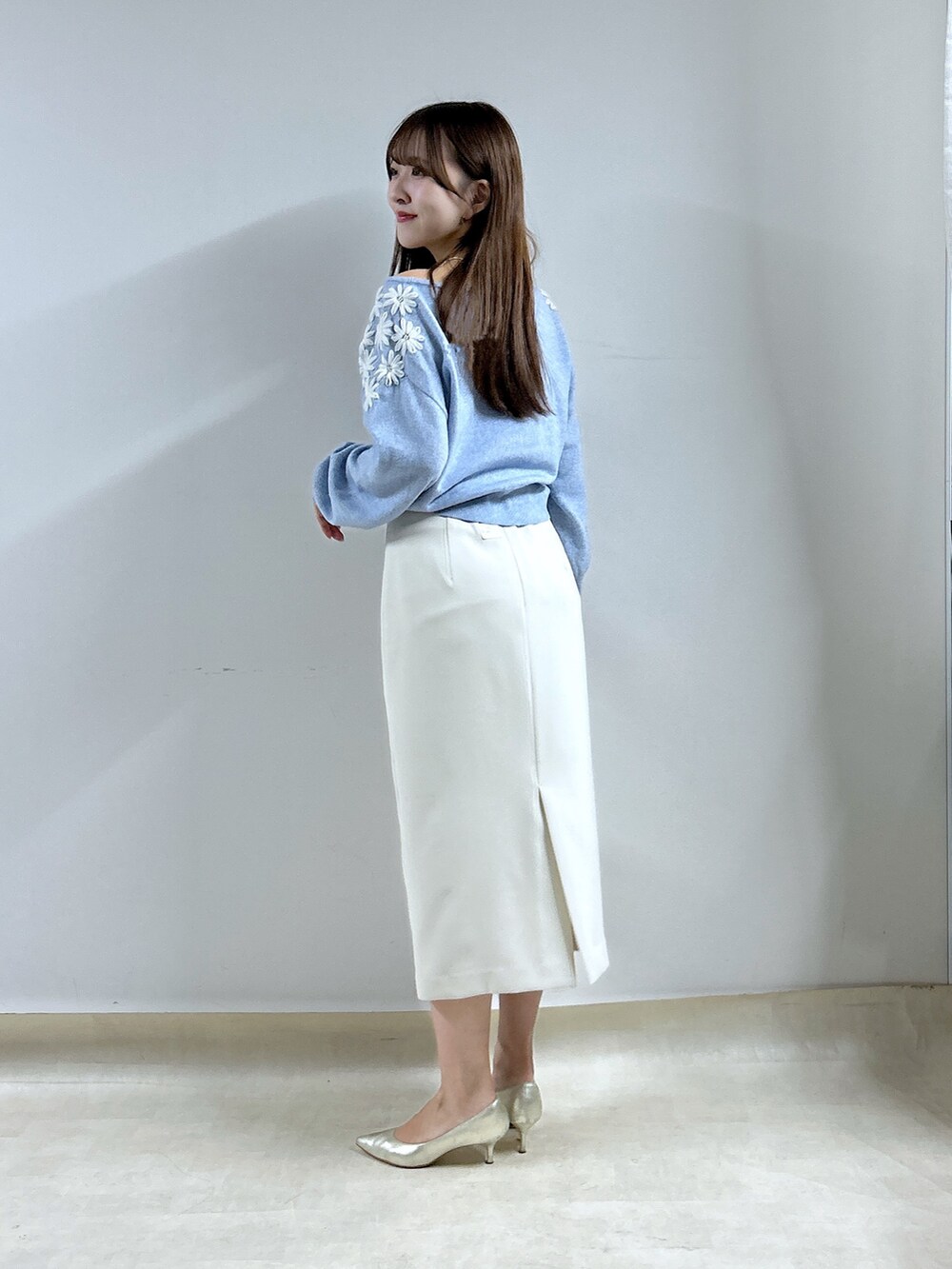 ブルー系のニット/セーター、ホワイト系のスカートを着用したレディースの秋コーディネートの3枚目の写真