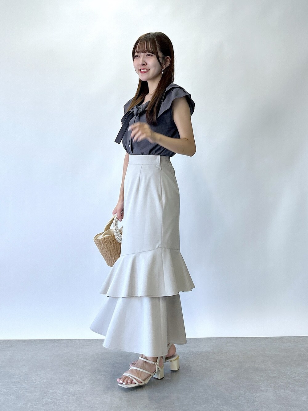 グレー系のシャツ/ブラウス、ベージュ系のスカートを着用したレディースの夏コーディネートの2枚目の写真