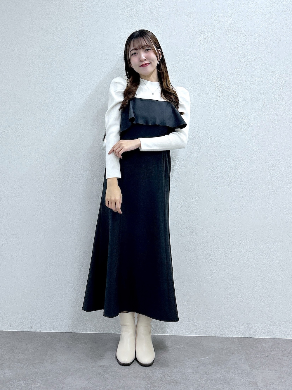 グレー系のワンピース、ホワイト系のニット/セーターを着用したレディースの秋コーディネートの2枚目の写真