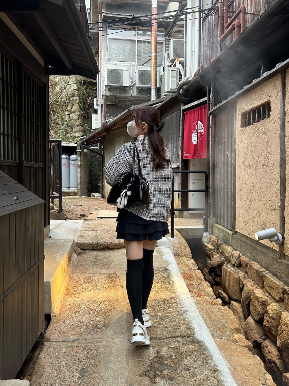 ブラック系のノーカラージャケットを着用したレディースの春コーディネートの3枚目の写真