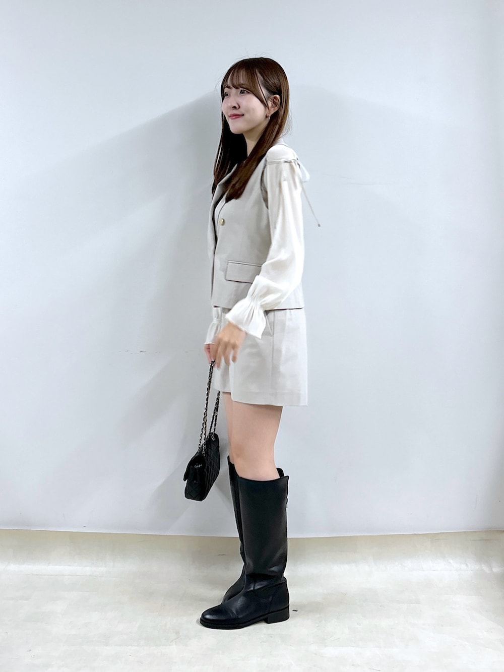 ベージュ系のその他パンツ、ホワイト系のTシャツ/カットソー、ベージュ系のベストを着用したレディースの秋コーディネートの2枚目の写真