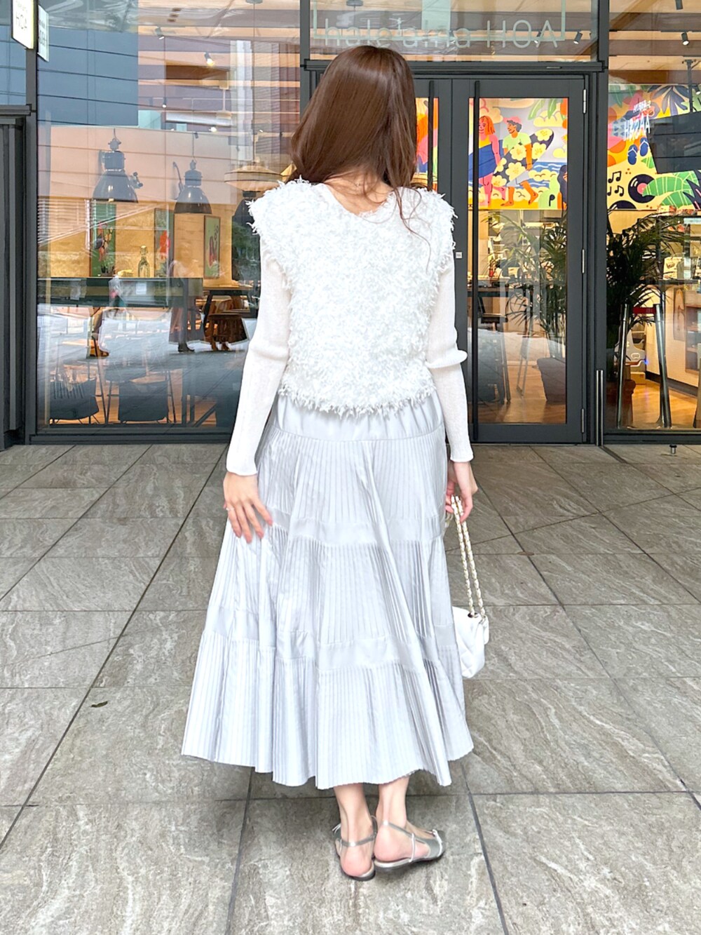 ホワイト系のシャツ/ブラウス、グレー系のスカート、ホワイト系のニット/セーターを着用したレディースの春コーディネートの4枚目の写真