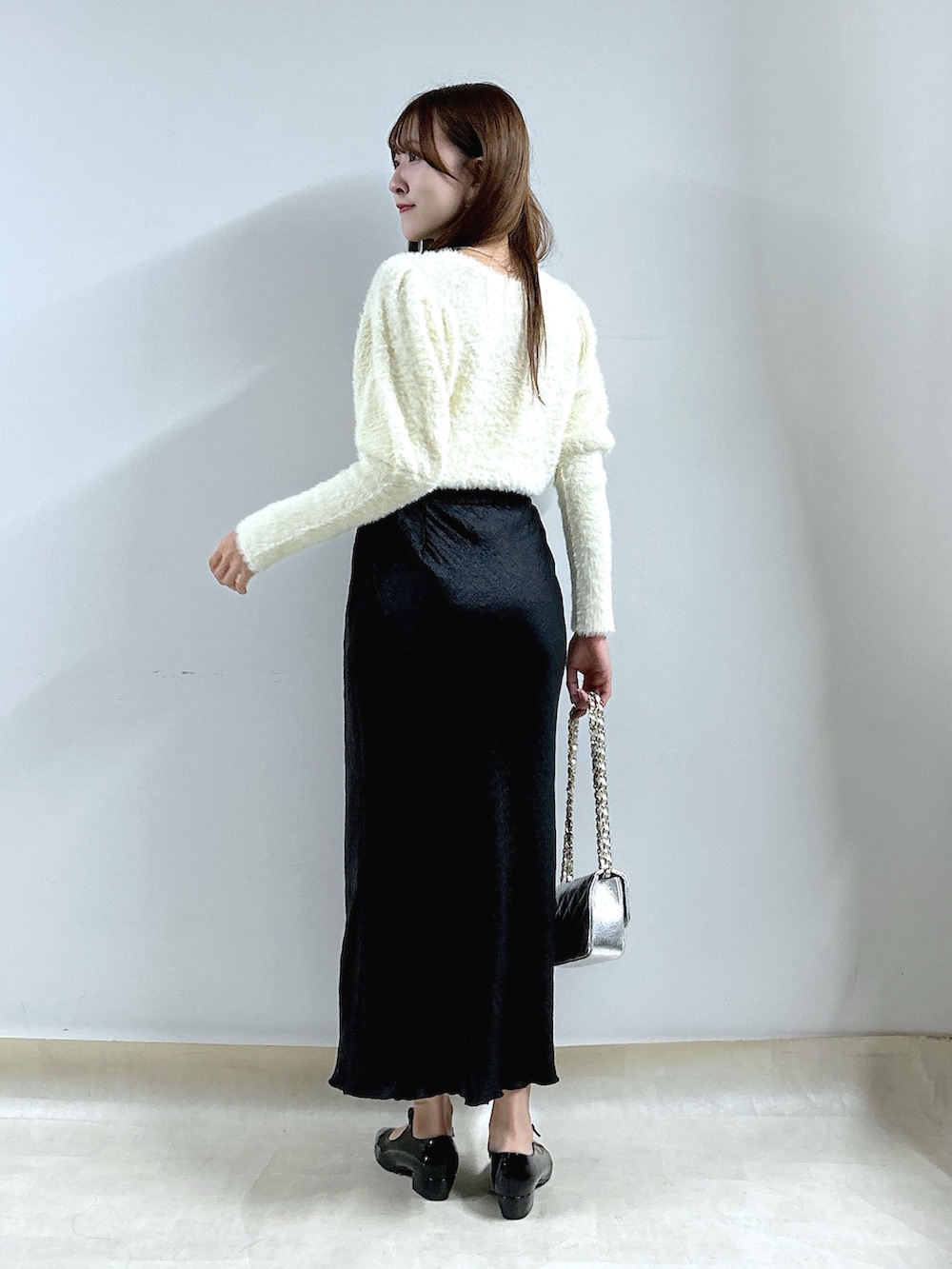 ホワイト系のニット/セーター、ブラック系のスカートを着用したレディースの秋コーディネートの3枚目の写真