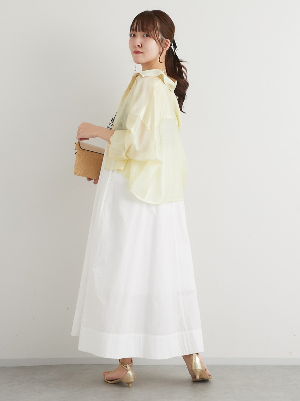ホワイト系のトートバッグ、イエロー系のシャツ/ブラウス、ホワイト系のワンピースを着用したレディースの春コーディネートの5枚目の写真