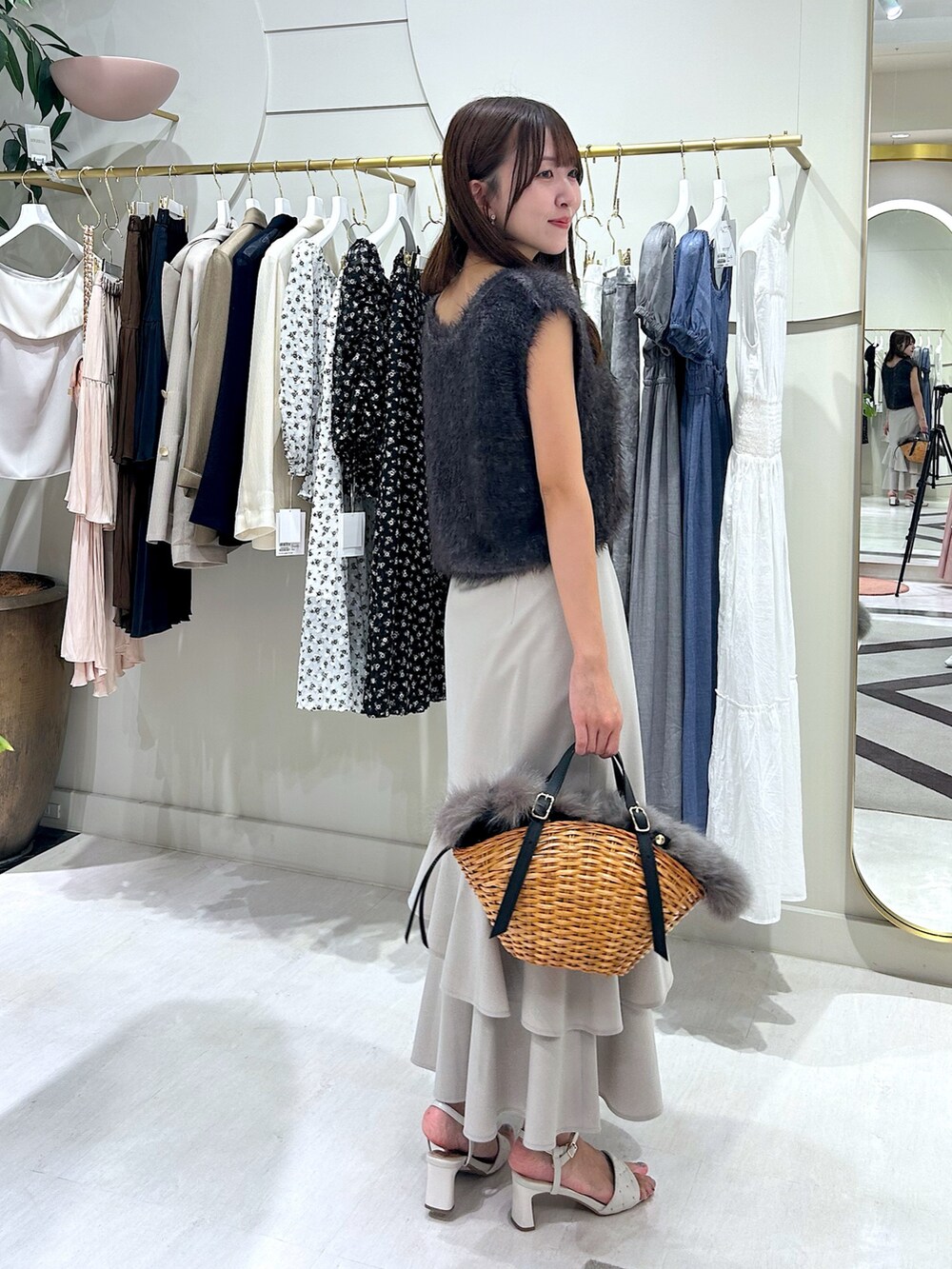 グレー系のベスト、ベージュ系のスカートを着用したレディースの夏コーディネートの3枚目の写真