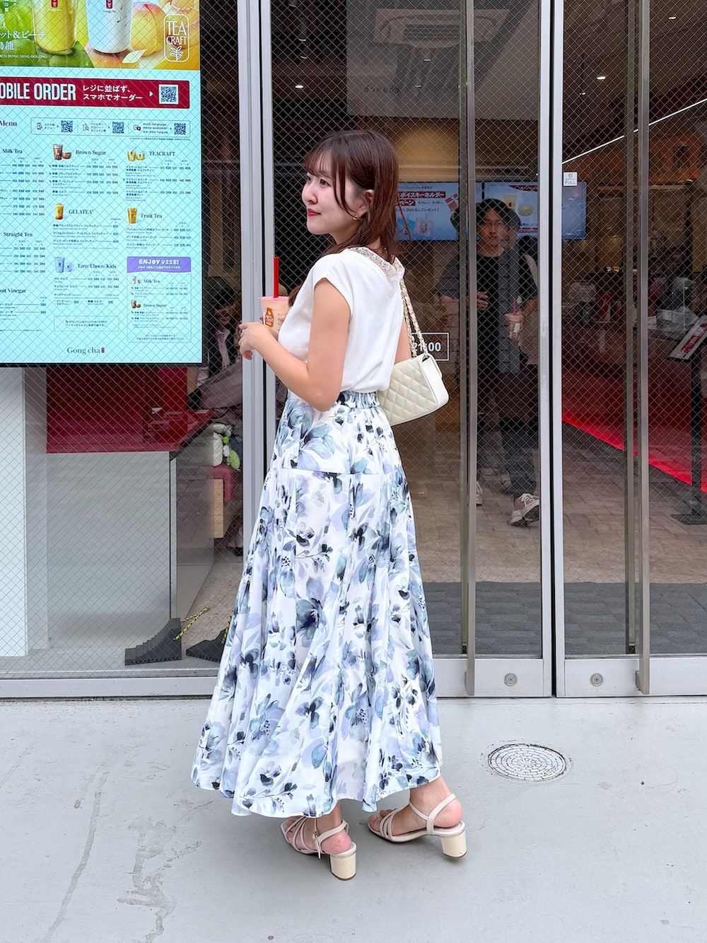 ホワイト系のニット/セーター、ホワイト系のスカートを着用したレディースの夏コーディネートの2枚目の写真
