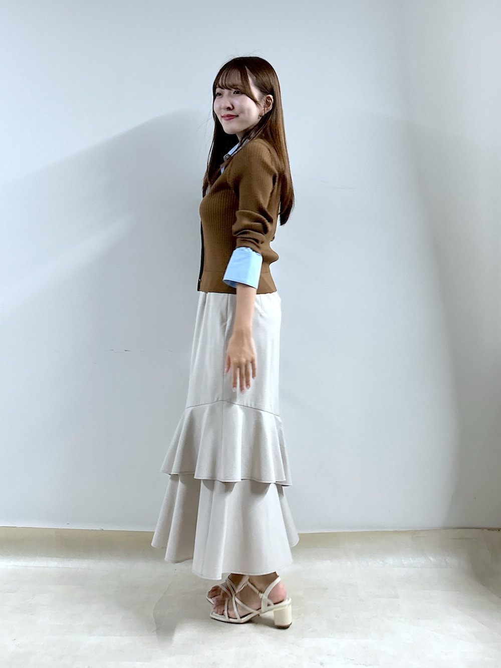 ブラウン系のニット/セーター、ベージュ系のスカートを着用したレディースの秋コーディネートの2枚目の写真