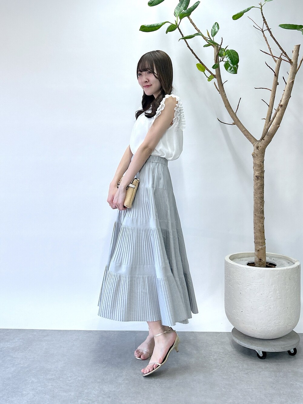 ホワイト系のシャツ/ブラウス、グレー系のスカートを着用したレディースの春コーディネートの2枚目の写真