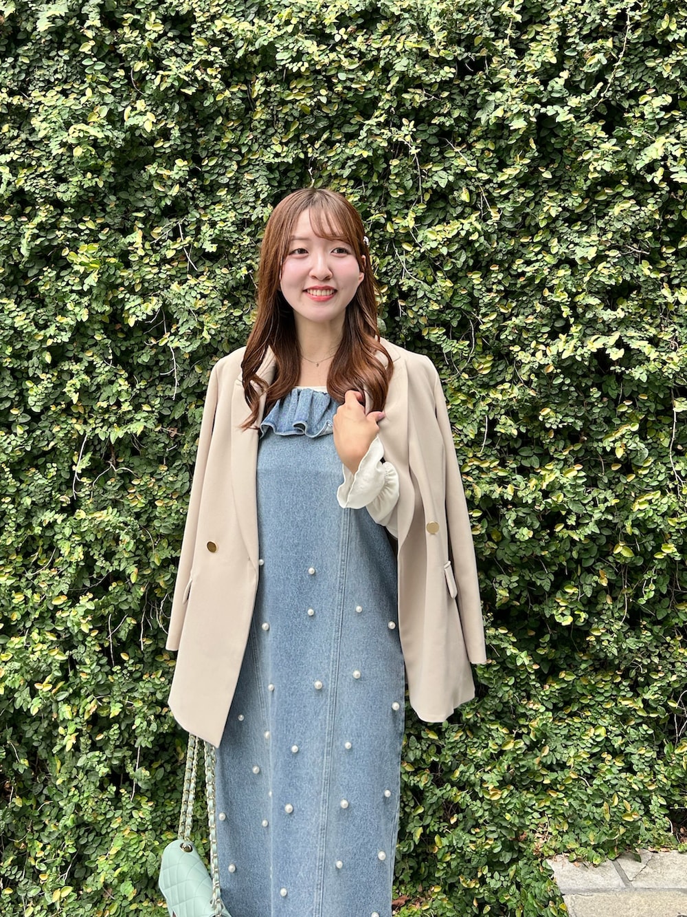 ブルー系のワンピース、ベージュ系のテーラードジャケットを着用したレディースの秋コーディネートの4枚目の写真