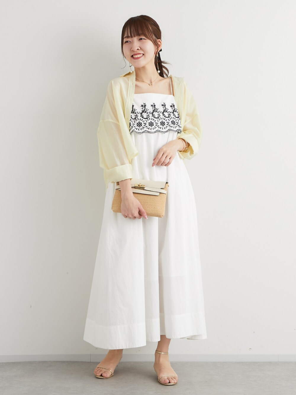 ホワイト系のトートバッグ、イエロー系のシャツ/ブラウス、ホワイト系のワンピースを着用したレディースの春コーディネートの2枚目の写真