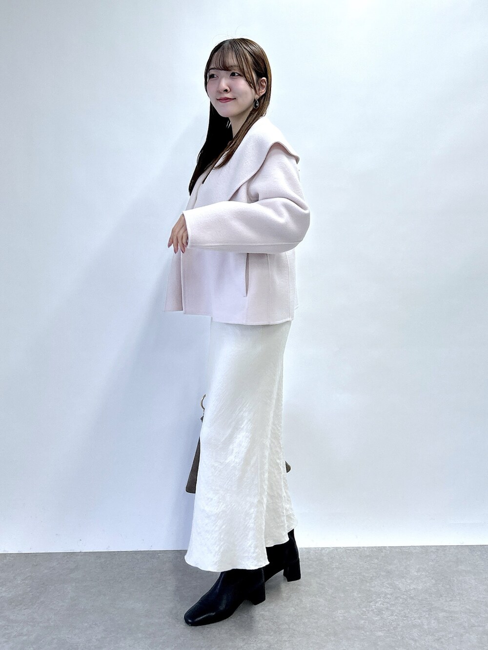 ピンク系のその他アウター、ホワイト系のニット/セーター、グレー系のスカートを着用したレディースの秋コーディネートの2枚目の写真