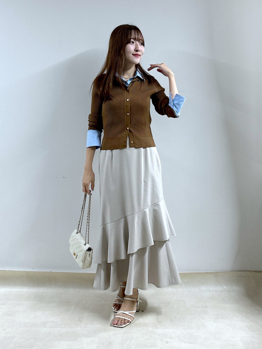 ブラウン系のニット/セーター、ベージュ系のスカートを着用したレディースの秋コーディネートの4枚目の写真