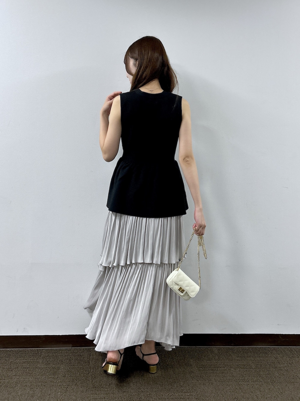 ブラック系のニット/セーター、グレー系のスカートを着用したレディースの春コーディネートの3枚目の写真