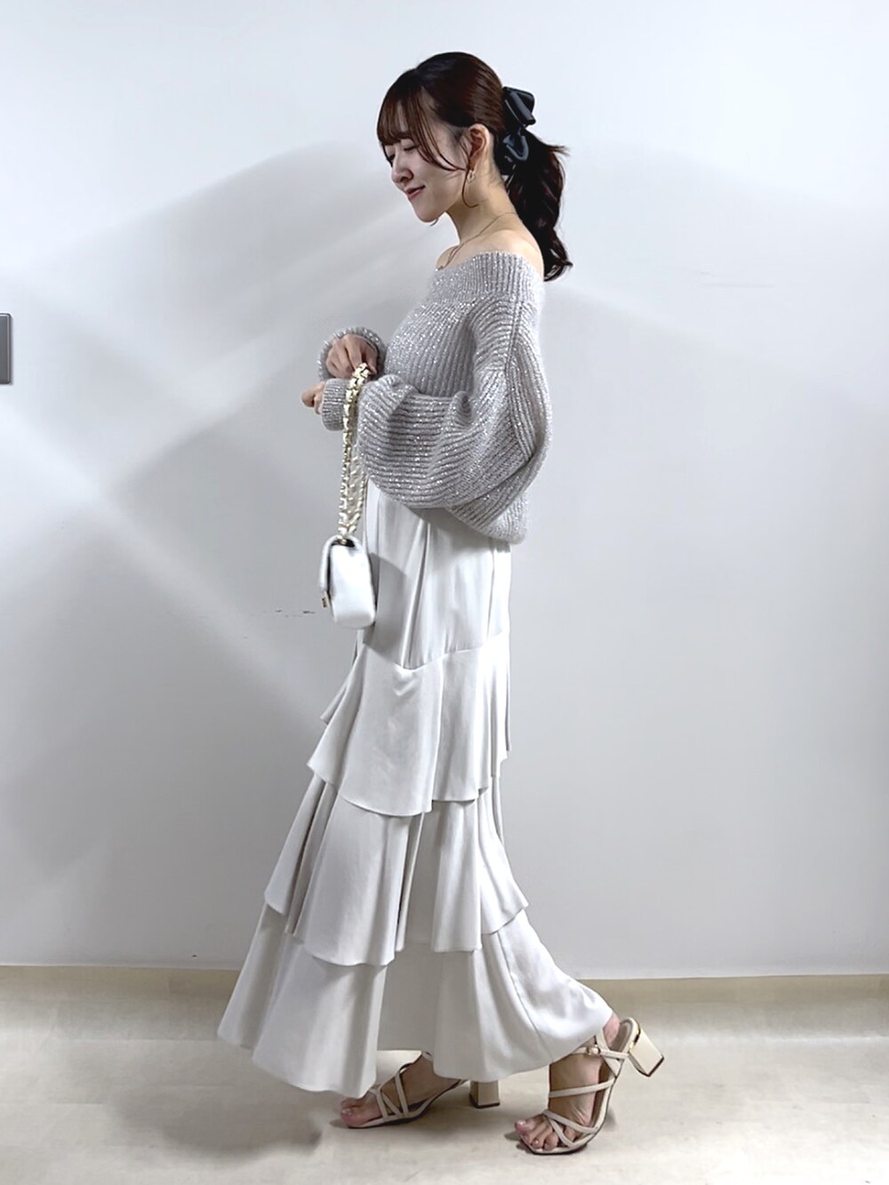 シルバー系のニット/セーター、グレー系のスカートを着用したレディースの秋コーディネートの2枚目の写真