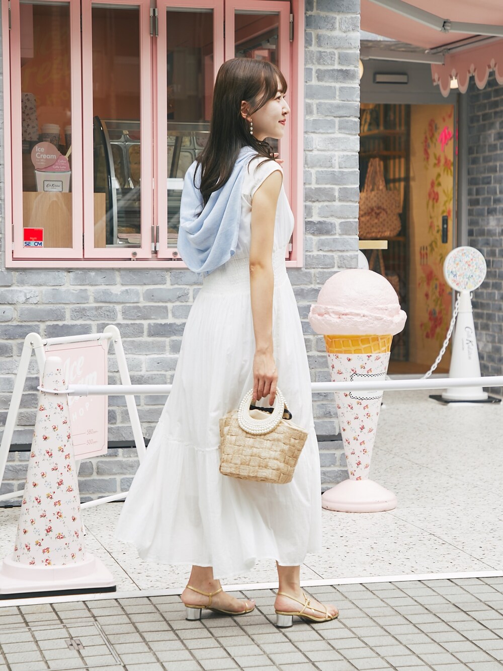 ホワイト系のワンピース、ブルー系のカーディガン/ボレロを着用したレディースの夏コーディネートの3枚目の写真