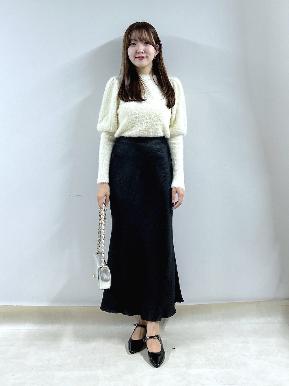 ホワイト系のニット/セーター、ブラック系のスカートを着用したレディースの秋コーディネートの4枚目の写真