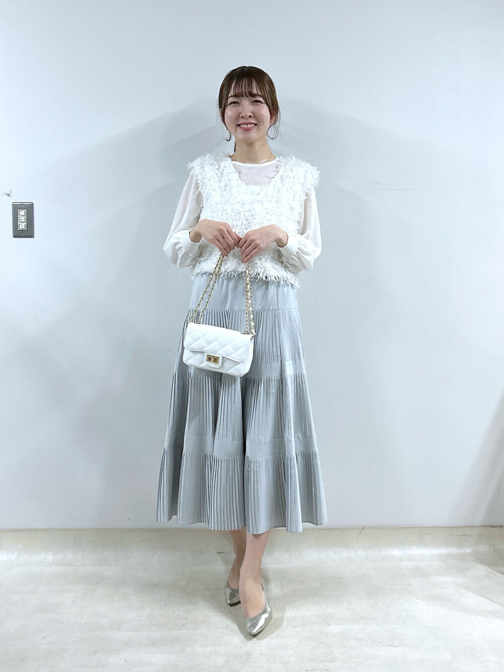 ホワイト系のシャツ/ブラウス、グレー系のスカート、ホワイト系のニット/セーターを着用したレディースの冬コーディネートの4枚目の写真