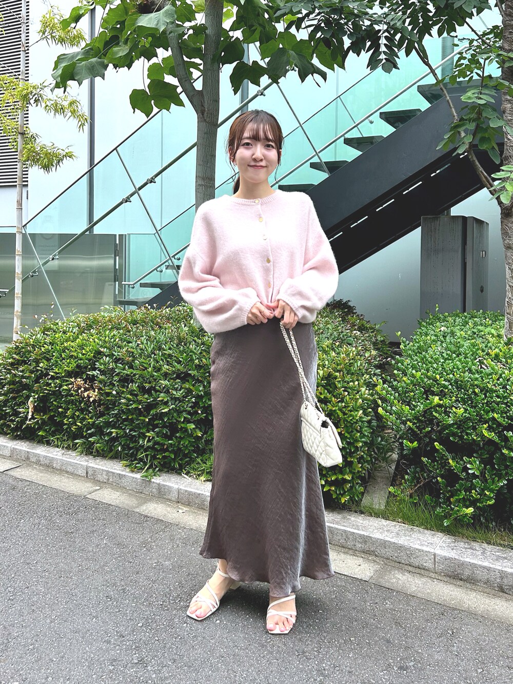 ピンク系のカーディガン/ボレロ、ブラウン系のスカート、ホワイト系のショルダーバッグを着用したレディースの秋コーディネートの2枚目の写真