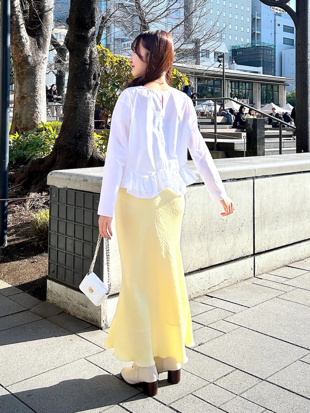 ホワイト系のシャツ/ブラウス、イエロー系のスカートを着用したレディースの冬コーディネートの3枚目の写真