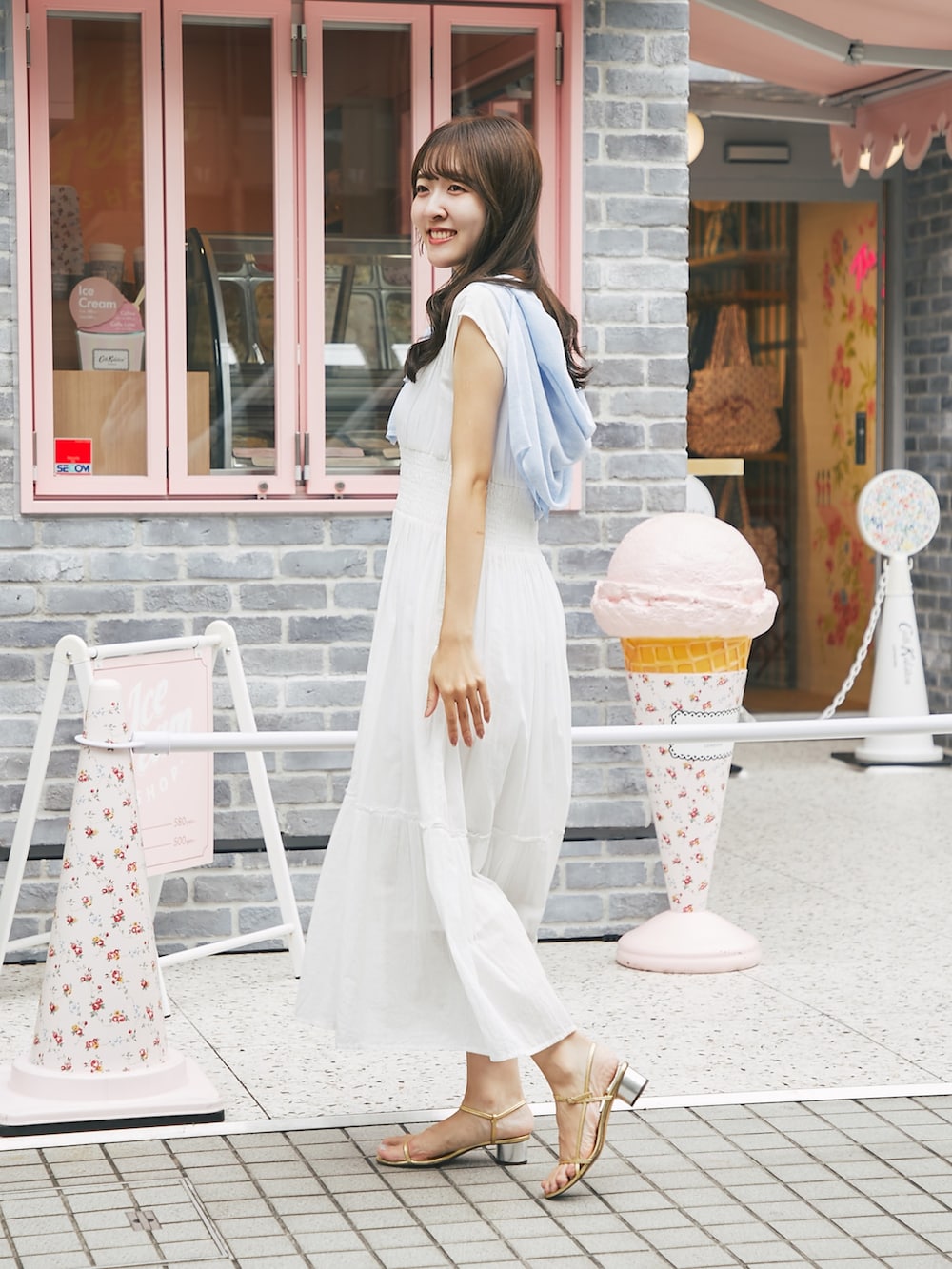ホワイト系のワンピース、ブルー系のカーディガン/ボレロを着用したレディースの夏コーディネートの2枚目の写真
