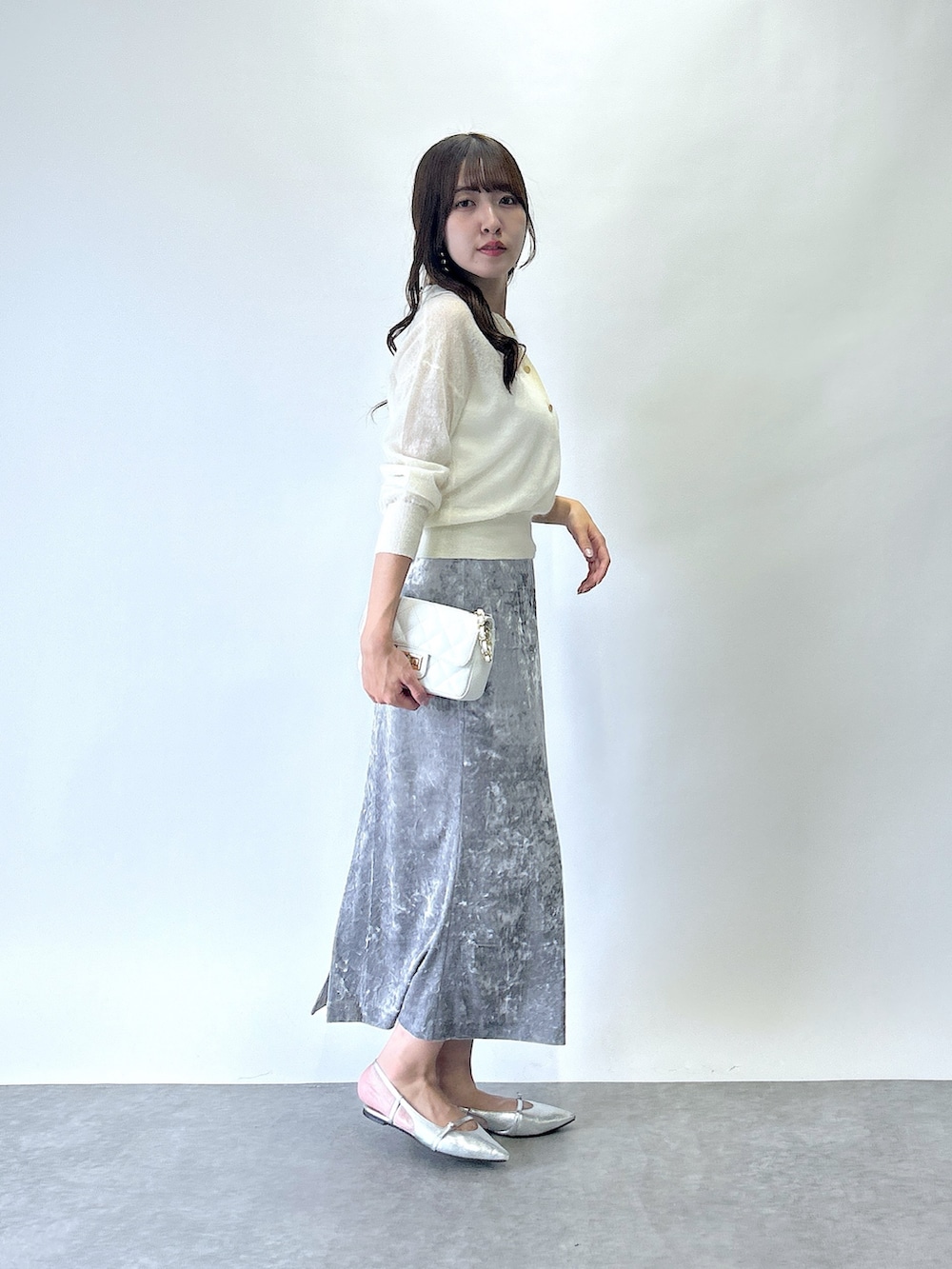 ホワイト系のニット/セーター、グレー系のスカートを着用したレディースの夏コーディネートの2枚目の写真