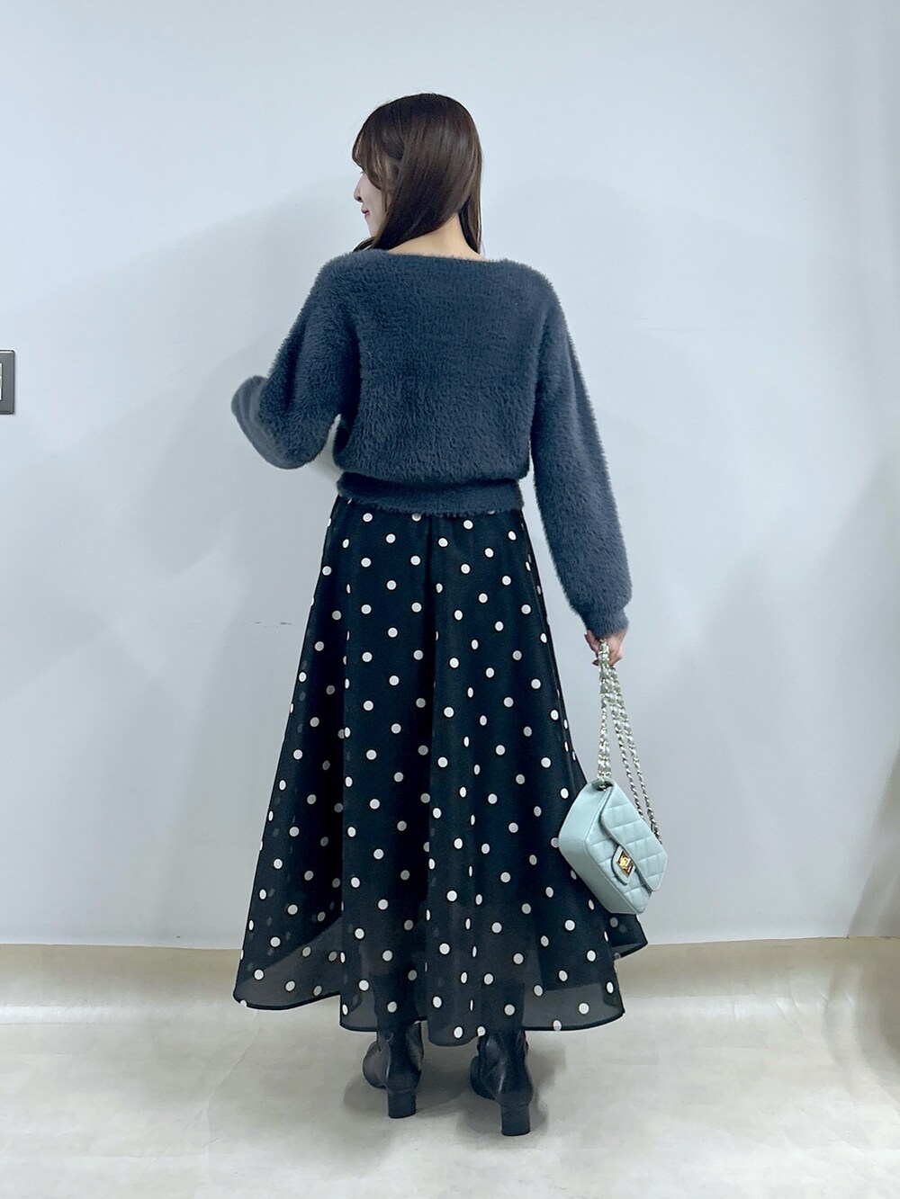 グレー系のカーディガン/ボレロ、ブルー系のスカートを着用したレディースの秋コーディネートの3枚目の写真