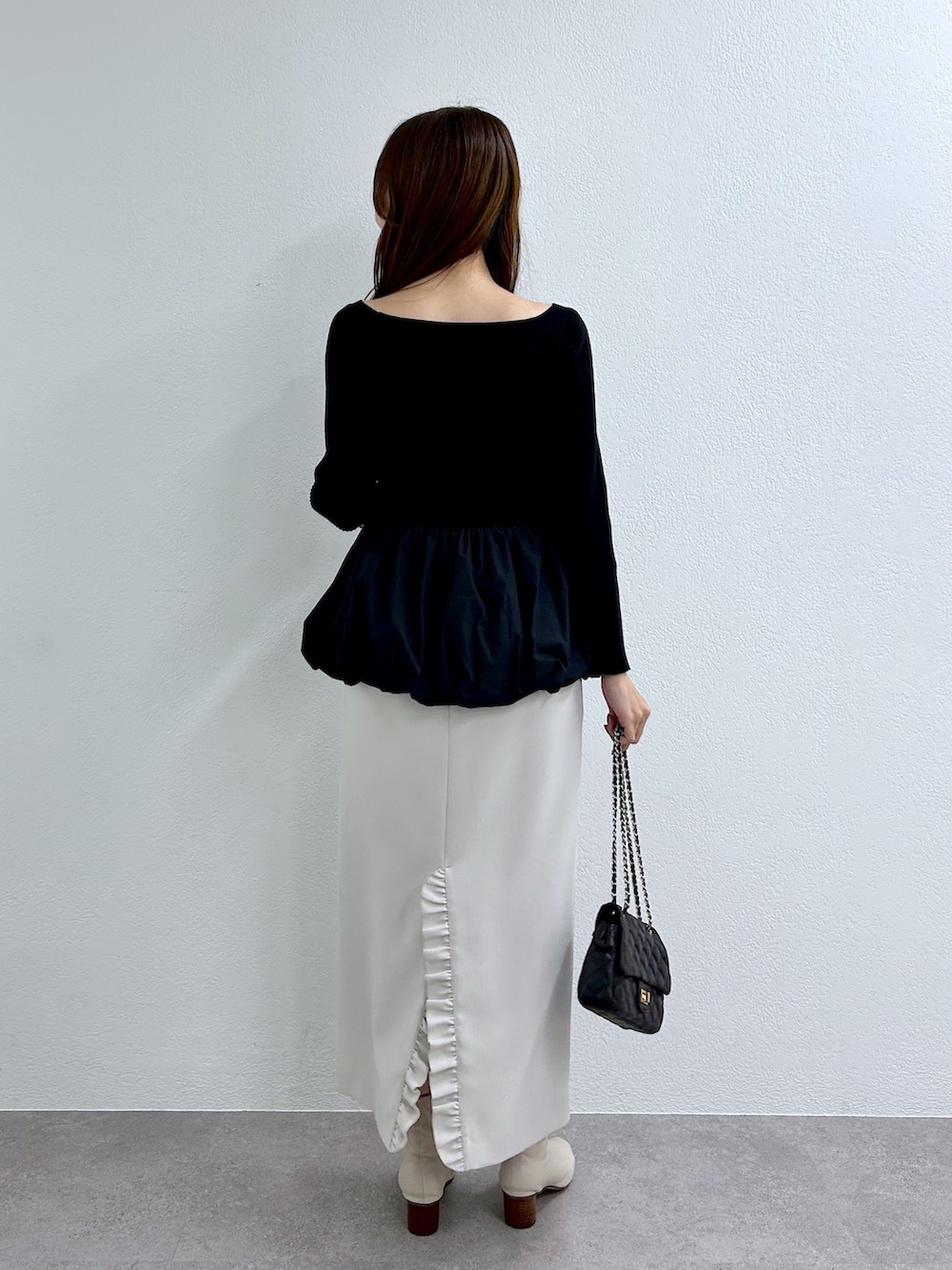 ブラック系のニット/セーター、グレー系のスカートを着用したレディースの秋コーディネートの4枚目の写真