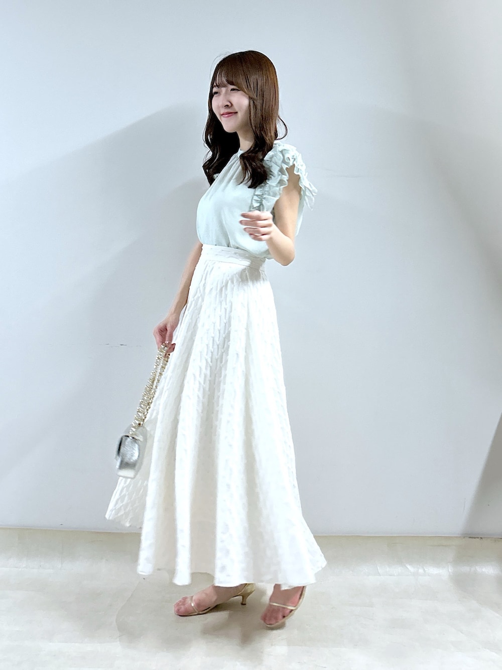 グリーン系のシャツ/ブラウス、ホワイト系のスカートを着用したレディースの春コーディネートの2枚目の写真