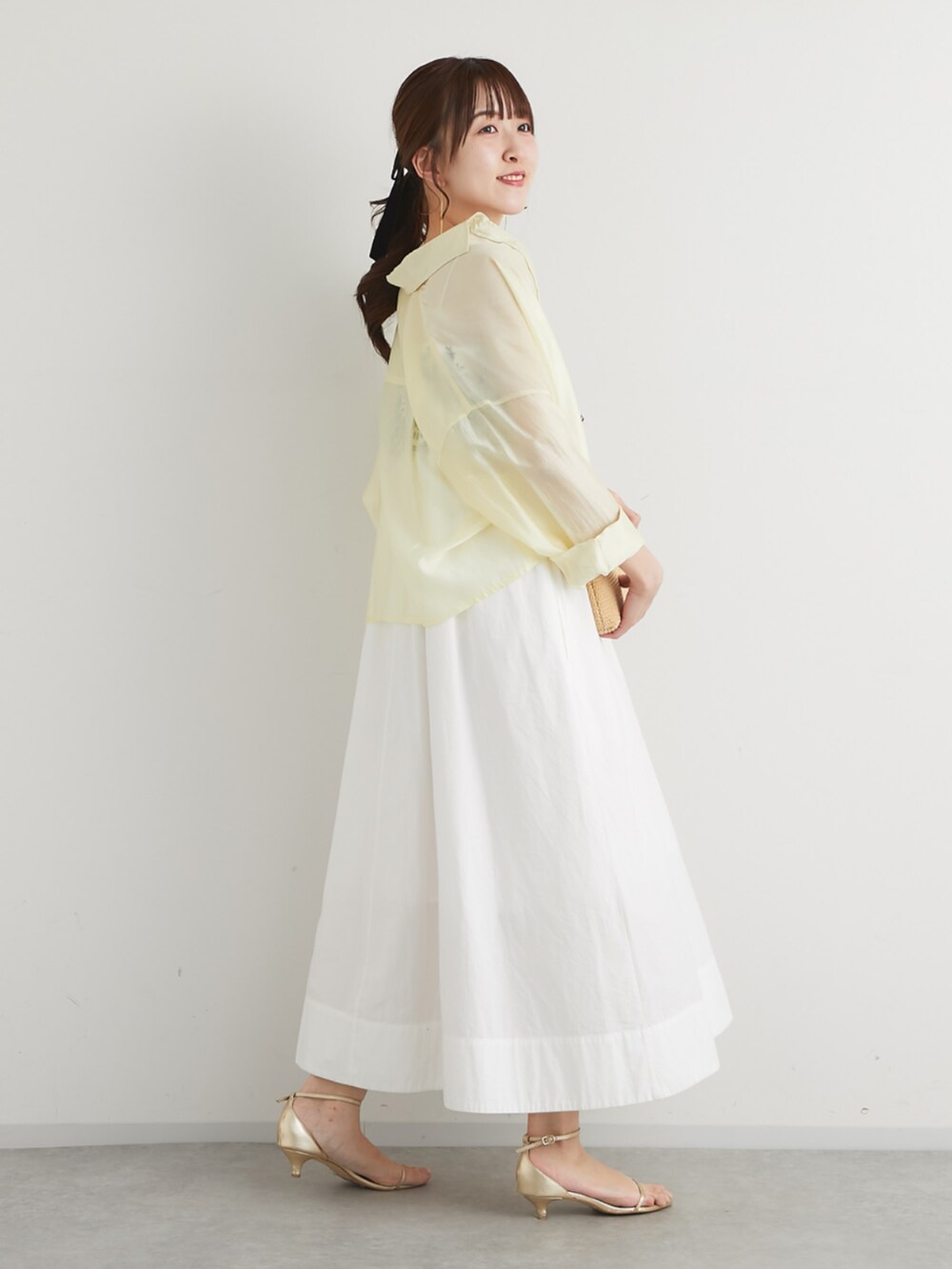ホワイト系のトートバッグ、イエロー系のシャツ/ブラウス、ホワイト系のワンピースを着用したレディースの春コーディネートの3枚目の写真