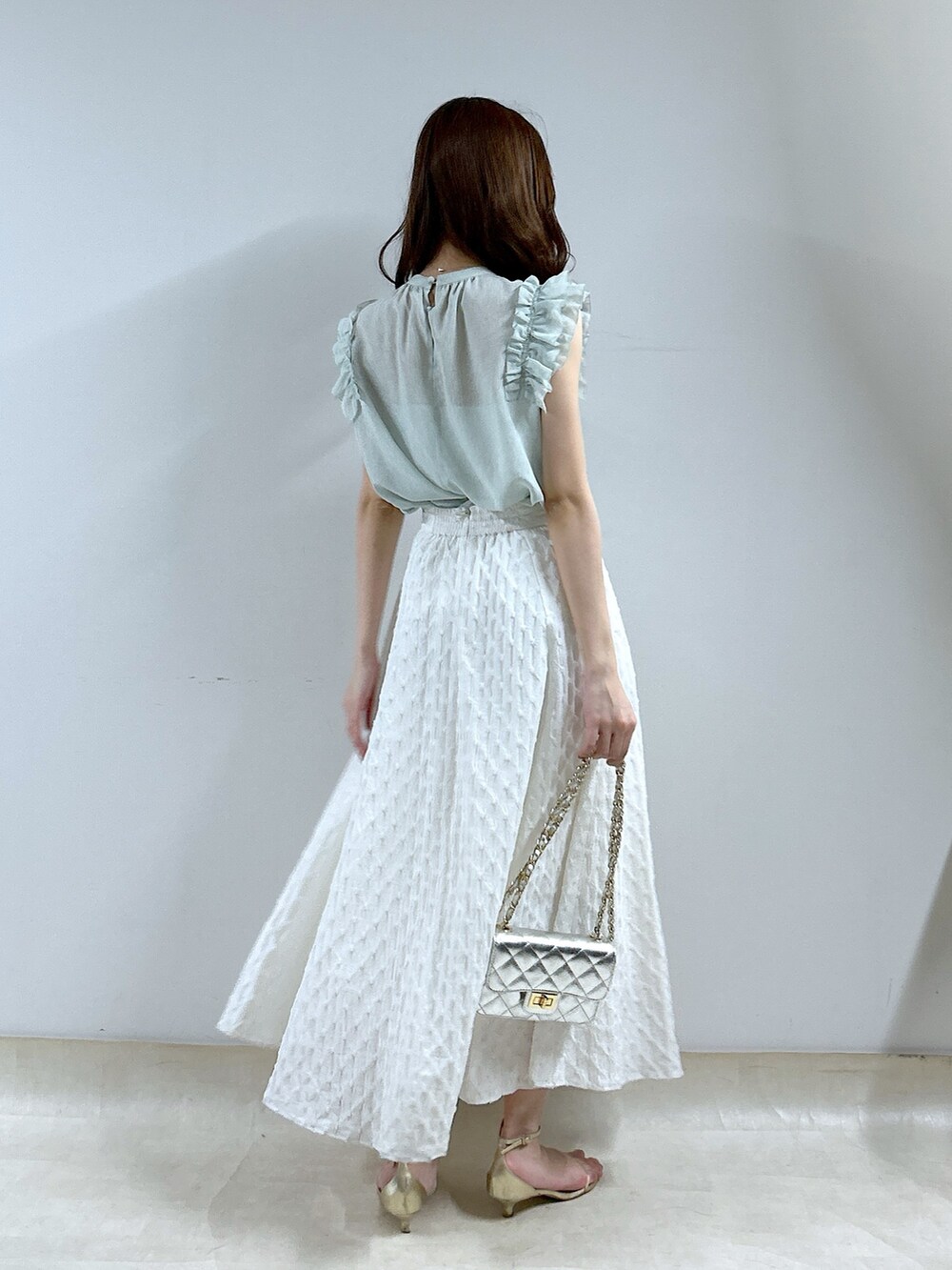 グリーン系のシャツ/ブラウス、ホワイト系のスカートを着用したレディースの春コーディネートの3枚目の写真