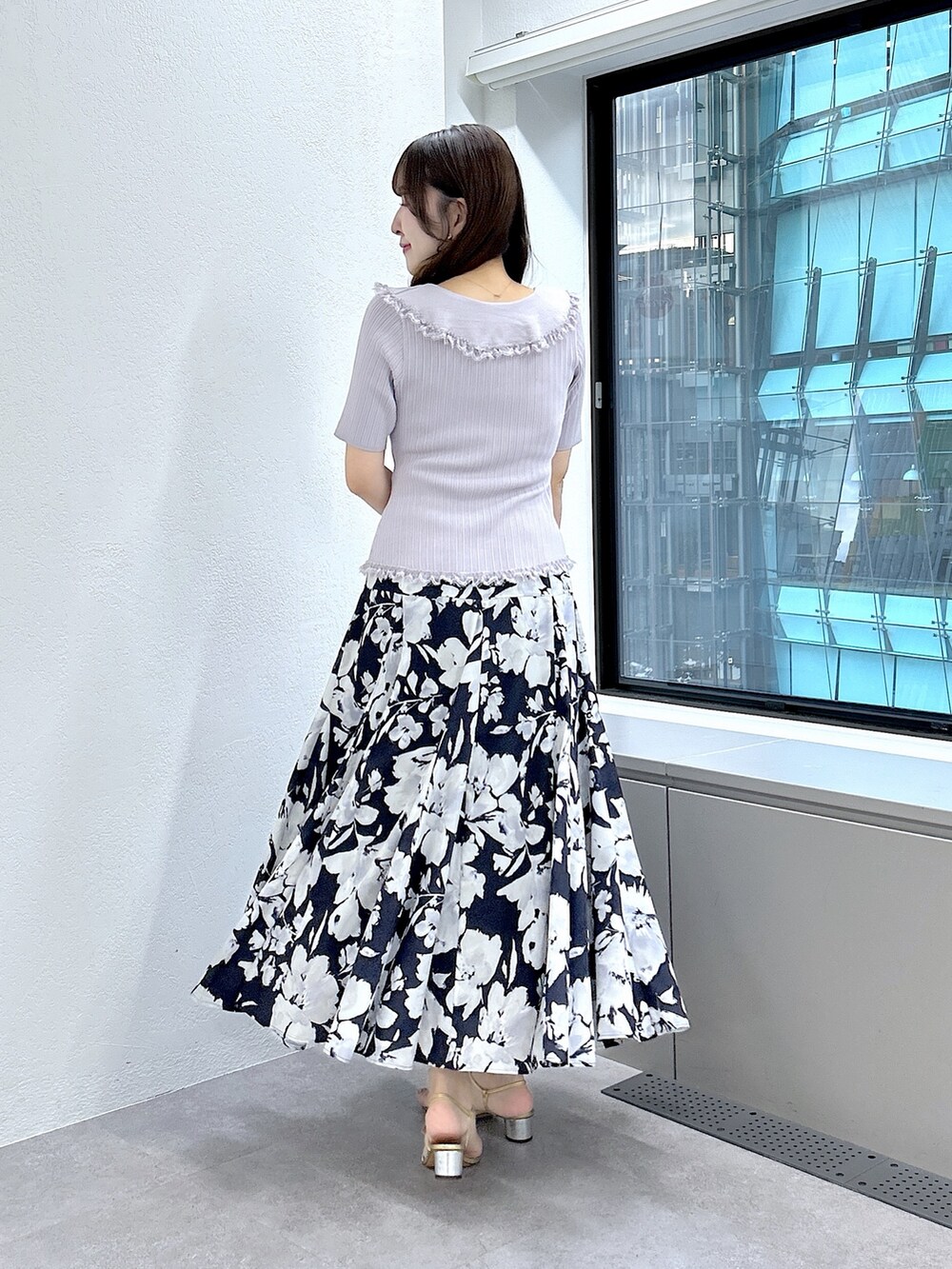 パープル系のニット/セーター、ブルー系のスカートを着用したレディースの夏コーディネートの3枚目の写真