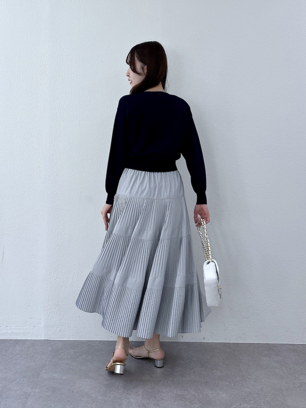 ブルー系のカーディガン/ボレロ、グレー系のスカートを着用したレディースの冬コーディネートの3枚目の写真