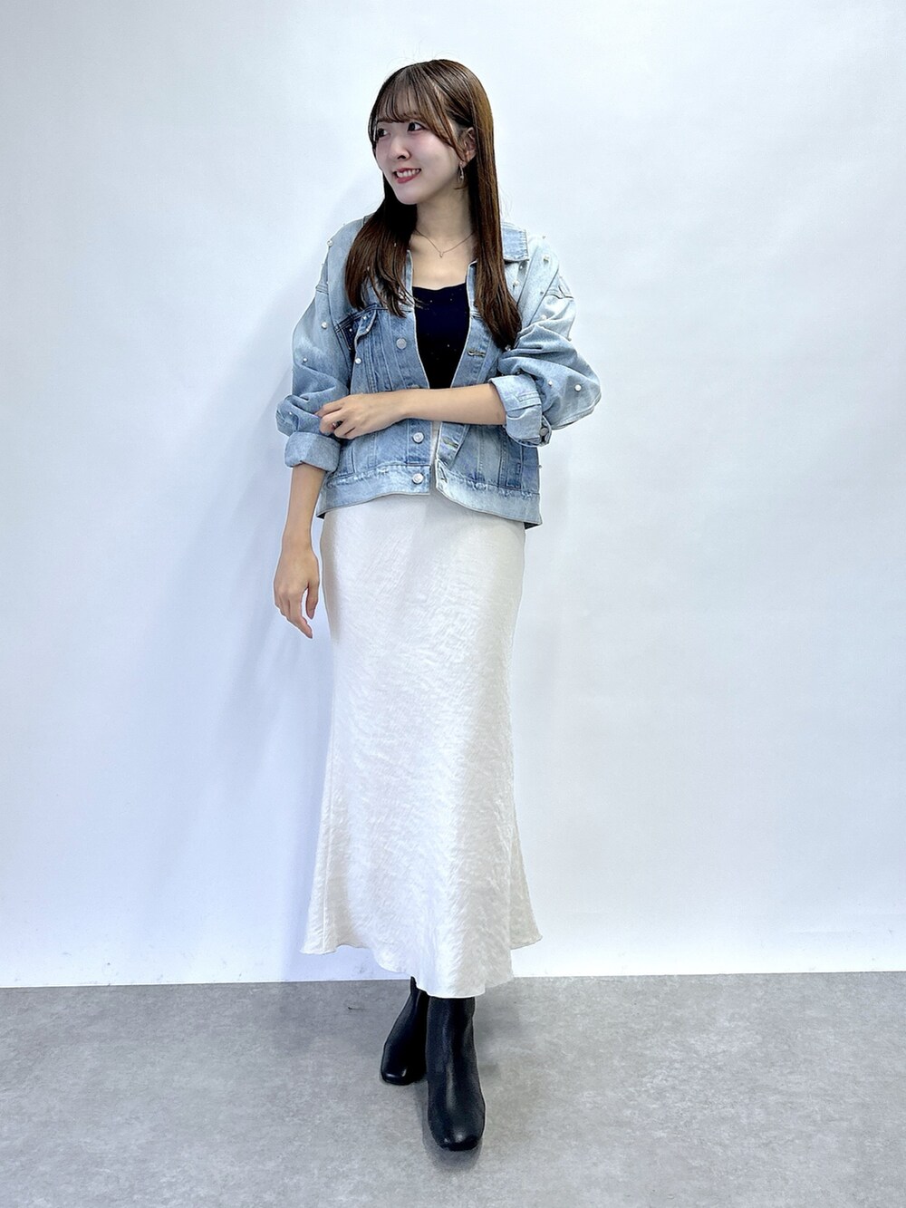 ブルー系のデニムジャケット、ブルー系のニット/セーター、グレー系のスカートを着用したレディースの秋コーディネートの3枚目の写真