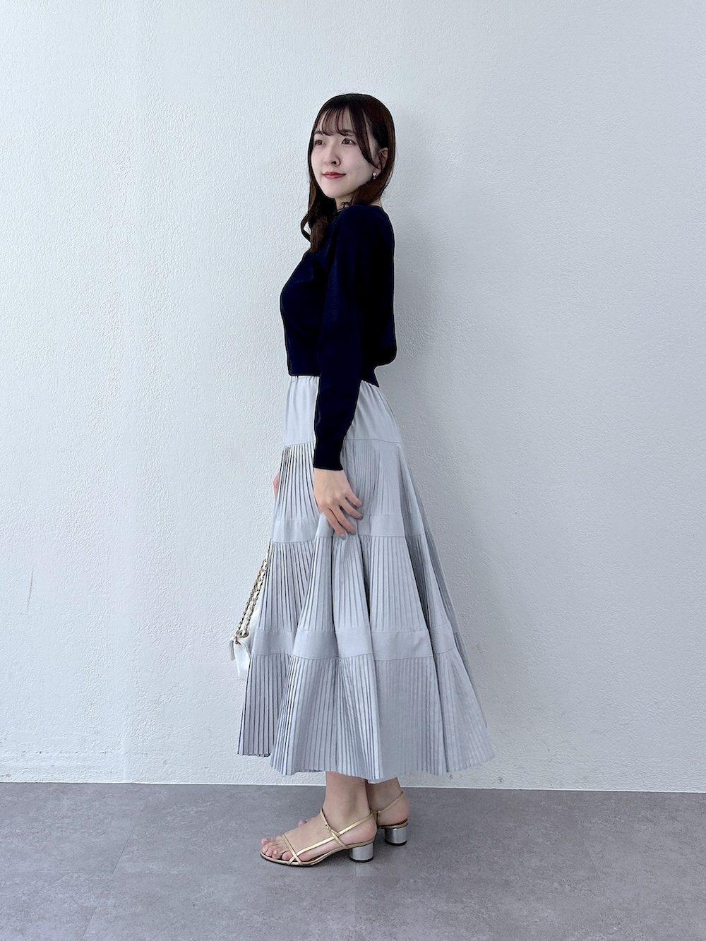 ブルー系のカーディガン/ボレロ、グレー系のスカートを着用したレディースの冬コーディネートの2枚目の写真