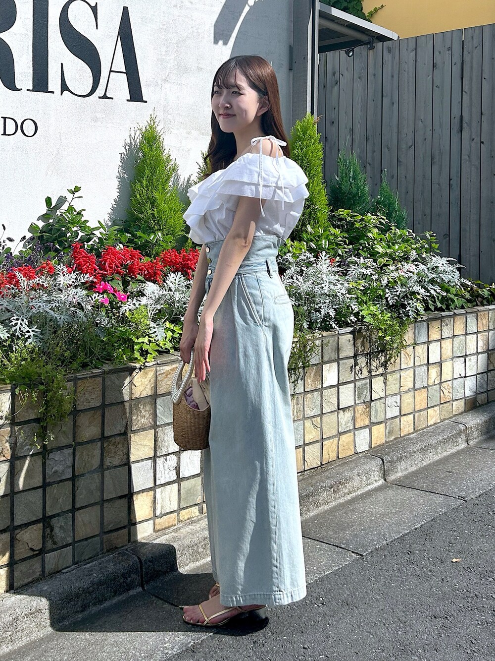 ホワイト系のシャツ/ブラウス、ブルー系のデニムパンツ、ベージュ系のかごバッグを着用したレディースの春コーディネートの3枚目の写真