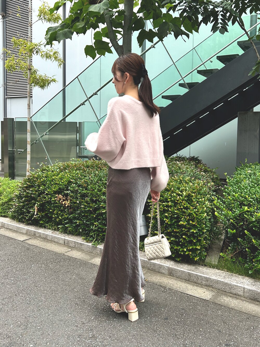 ピンク系のカーディガン/ボレロ、ブラウン系のスカート、ホワイト系のショルダーバッグを着用したレディースの秋コーディネートの4枚目の写真